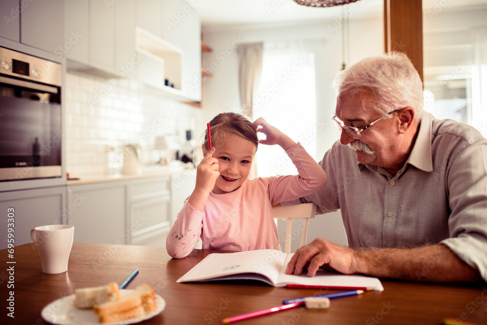 Grandfather and granddaughter drawing at home Grandfather and granddaughter drawing at home