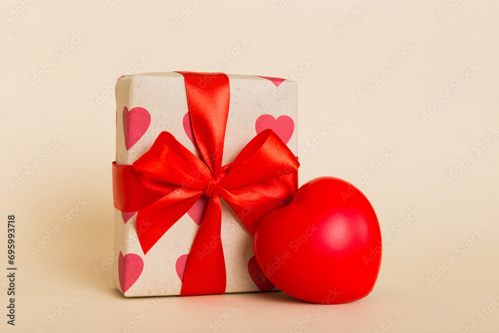 gift box with red bow and red heart on colored background. Perspective view. Flat lay gift box with red bow and red heart on colored background. Perspective view. Flat lay