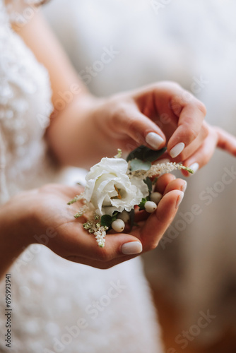 wedding boutonniere of flowers in the hands of the bride. Wedding details. The first meeting of the bride and groom. The bride is waiting for the groom.