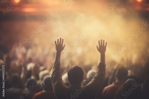 A person raising their hands in front of a crowd
