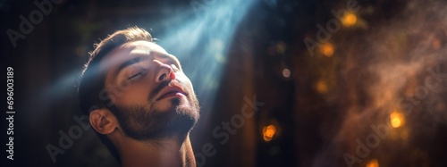 Man Engaged in Reiki Energy Healing Practice. A man in moment of tranquility during Reiki session, with sunlight illuminating his face, symbolizing the flow of healing energy. photo