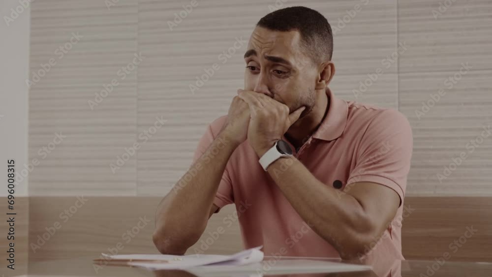 Homem emocionado, sentado a mesa, chorando apos assinar o divorcio. Cinematico 4k.