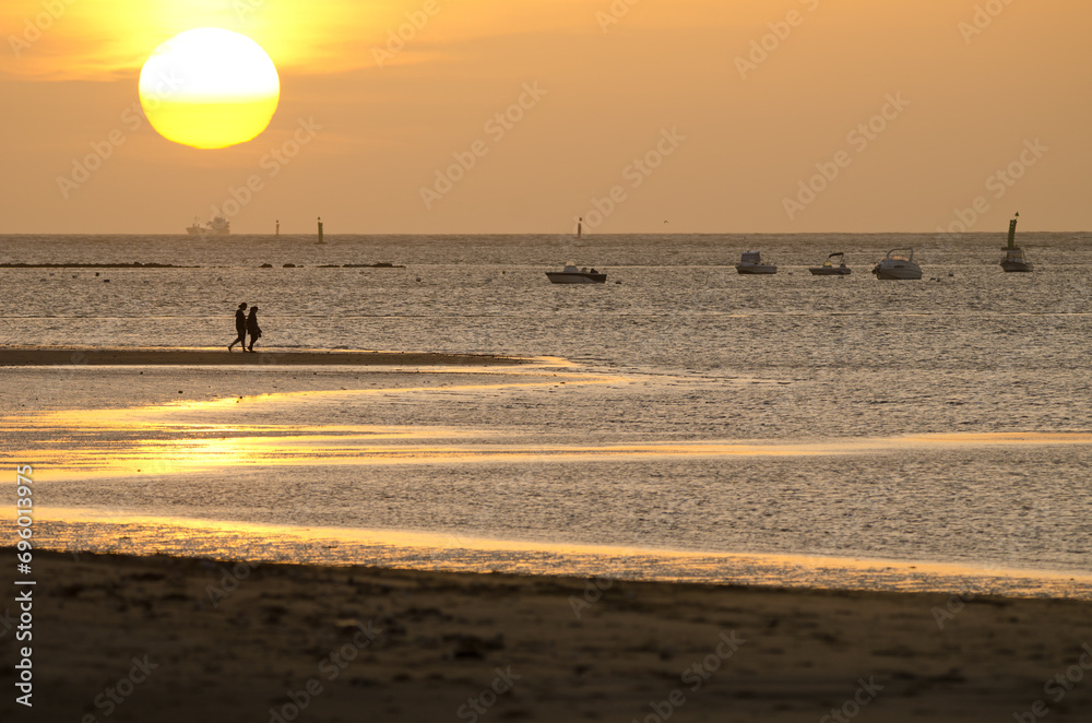 Couple strolling along the beach at sunset. Bonanza Beach. Sanlucar de Barrameda. Cadiz. Andalusia. Spain. Couple strolling along the beach at sunset. Bonanza Beach. Sanlucar de Barrameda. Cadiz. Andalusia. Spain.