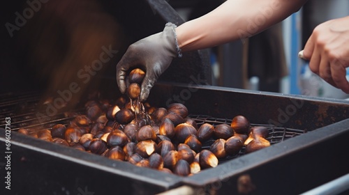 A man roasting chestnuts in Chinatown with a close-up view of his hand in motion. photo