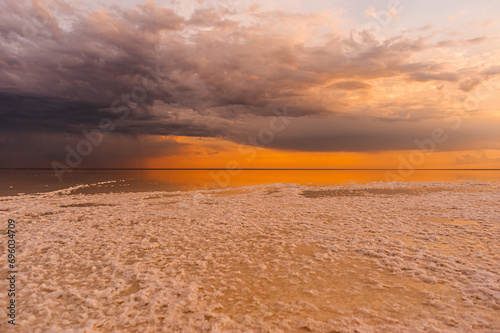Fototapeta Naklejka Na Ścianę i Meble -  Sunset or sunrise sky. Clouds over water. Golden Dawn. Dramatic coast nature background. Beautiful sea beach at sunset. Morning shoreline sunlight.	
