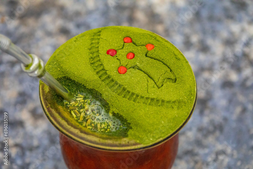 Traditional Brazilian chimarrão prepared with yerba mate (Ilex paraguariensis) decorated with a Christmas theme and with brazilwood seeds photo