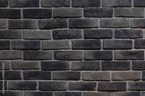 Detail of a section of a grey and black brick wall