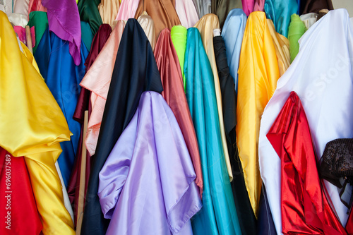 Shiny, colorful bulk fabrics outside a textile store.