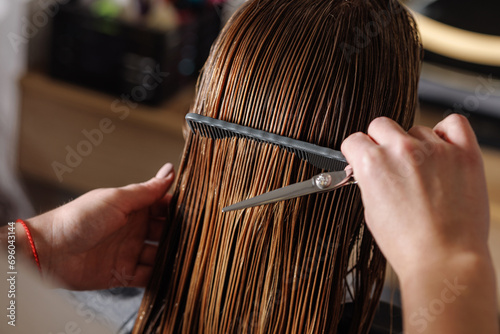 beauty master combing wet hair of a client in a beauty salon close-up