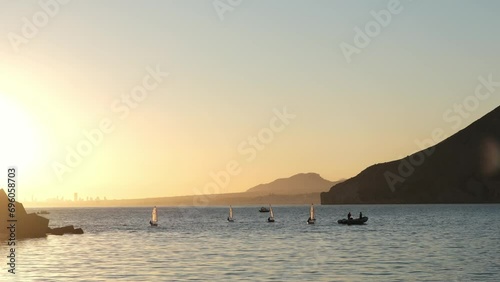 Sailors sport competition. Yacht club regatta in the open sea. Small yachts for training at sea. Yachting and sailing training. Summer sport. Athletes in the regatta. Calpe city, Spain. photo