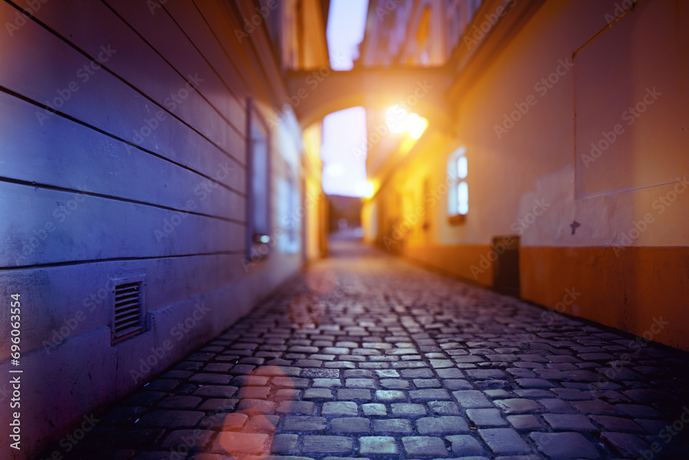 Vibrant city scene with illuminated architecture and cobblestone alley.