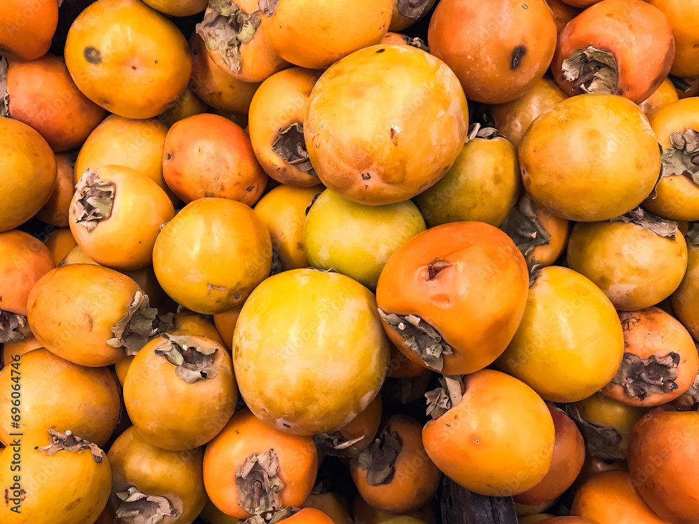 Persimmons in a box , fruit berry for food ripe yellow ,lying in box in supermarket .concept vitamins healthy food