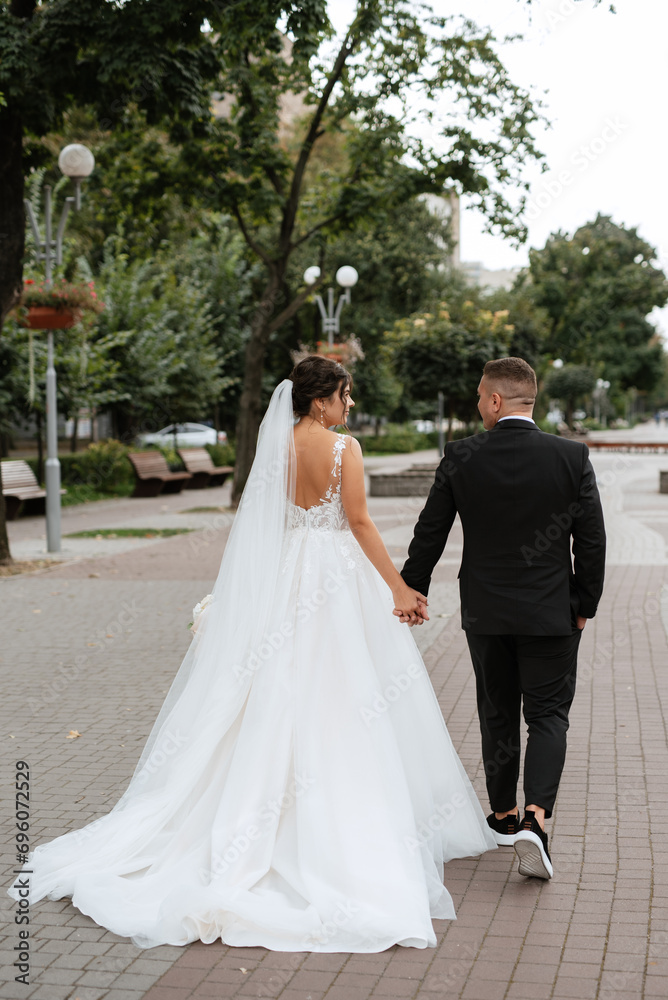 the groom in a brown suit and the bride in a white dress