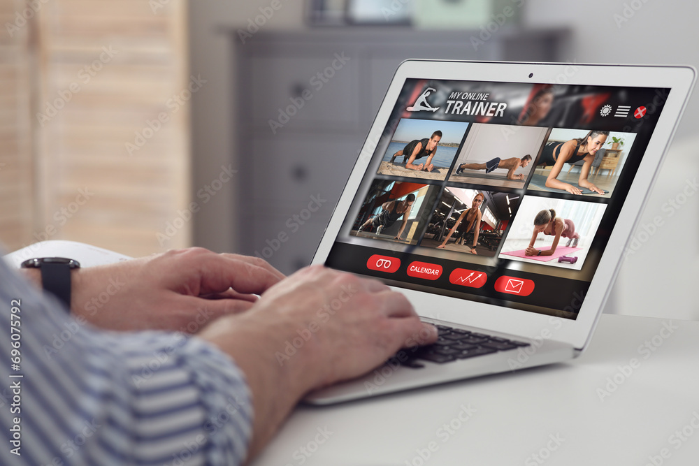 Personal trainer online. Man viewing website via laptop at home, closeup Personal trainer online. Man viewing website via laptop at home, closeup