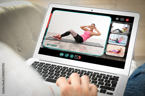 Personal trainer online. Man viewing website via laptop at home, closeup photo