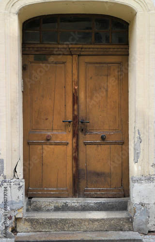 Old weathered, grunge and damaged wooden house entrance door