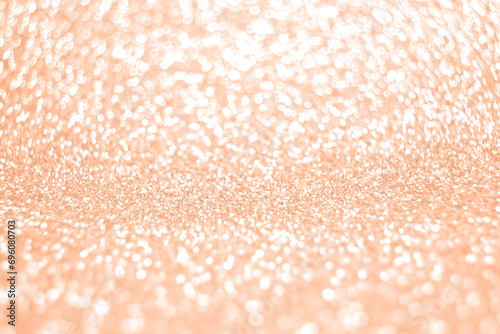 Trendy color of the year concept 2024. Peach pastel Lights on light orange background. Bokeh defocus disco effect. Holiday abstract christmas lights garland.