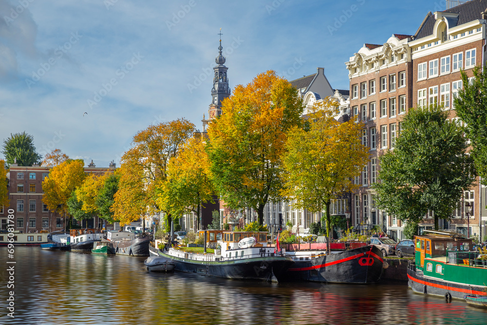 Amsterdam canal and houseboat/ townhouse with autumn colorful trees, Amsterdam