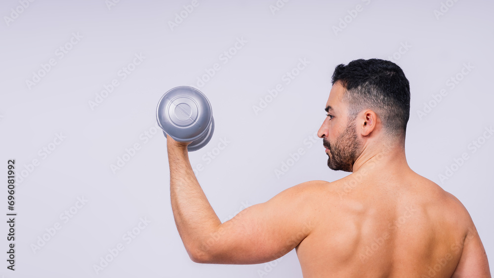 Athletic man doing exercises with dumbbell at biceps on white background. Strength and motivation