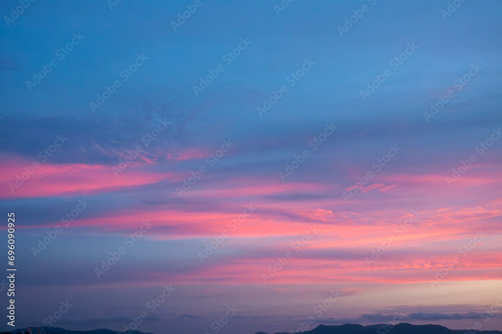 Amazing natural fenmen on the romantic colorful sunset sky with illuminated contrast warm clouds on the horizon surrounded by cinematic atmosphere 