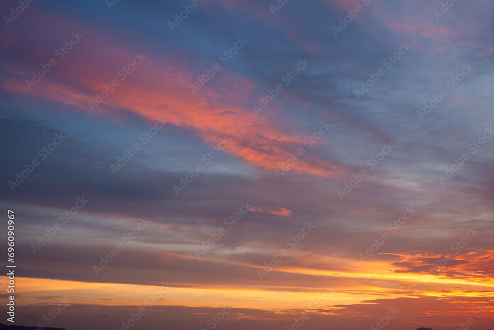 Amazing natural fenmen on the romantic colorful sunset sky with illuminated contrast warm clouds on the horizon surrounded by cinematic atmosphere 