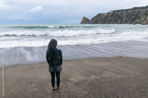 Woman watching the waves at Oleiros Beach, Cudillero. Western Asturias photo