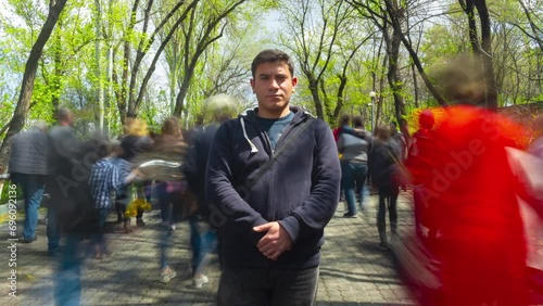 Wallpaper Mural A lone man stands motionless against a background of blurred people walking and green trees. 4K Time Lapse video. Torontodigital.ca