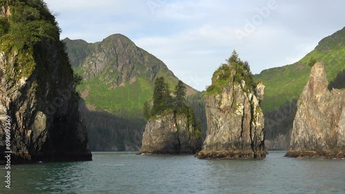 ALASKA - 2023 - View from a kayak as it approaches giant green-topped rocks and mountains in Alaska's Resurrection Bay. photo