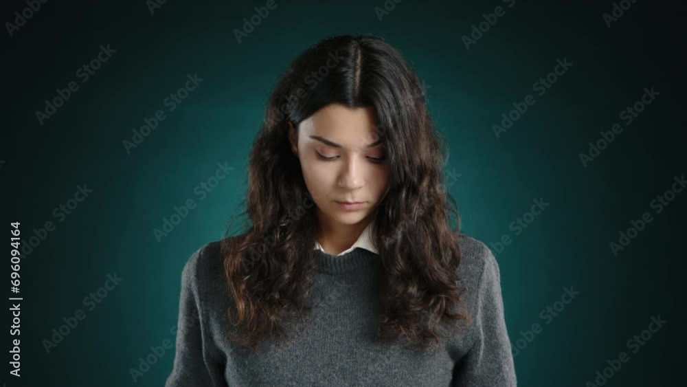 A young woman looks away from the camera, feeling guilty. She has made a mistake and feels awkward. High quality 4k footage