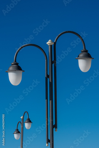 Street black lampposts, clear blue sky as background. photo