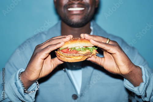 Foto Close up shot of tasty meaty hamburger with vegetables in hands of Black man sta