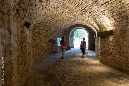 Two women are walking in an ancient tunnel