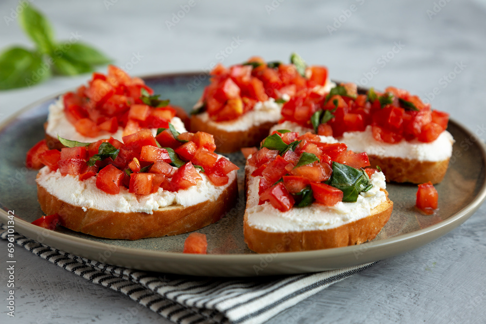 Homemade Tomato Ricotta Tartine on a Plate, low angle view. Close-up. Homemade Tomato Ricotta Tartine on a Plate, low angle view. Close-up.