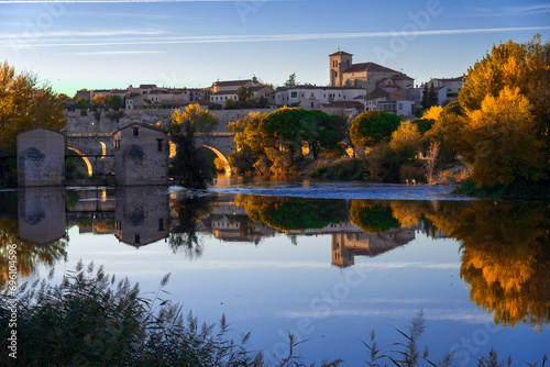 View of the city of Zamora and watermills and the San Pedro Church in the background in autmn at sunset reflected in the Duero river. Spain photo