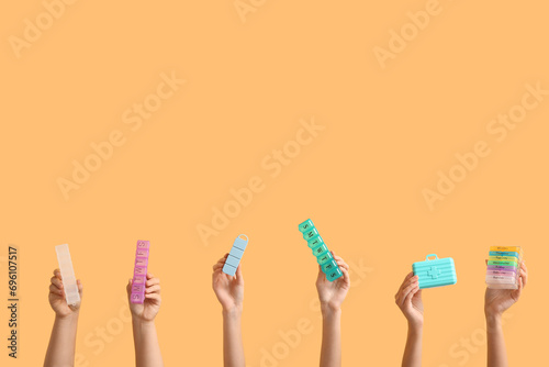 Female hands with different pill boxes on color background photo