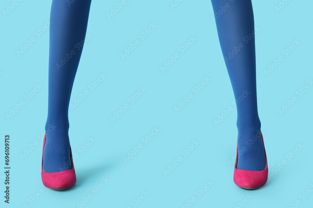 Legs of beautiful young woman in stylish high heels on blue background Legs of beautiful young woman in stylish high heels on blue background