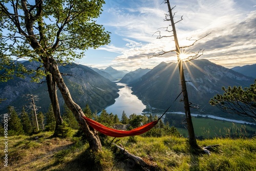 View of Plansee from Schoenjoechl with orange hammock, at sunset, sun star, panoramic view of mountains with lake, Plansee, Tyrol, Austria, Europe photo