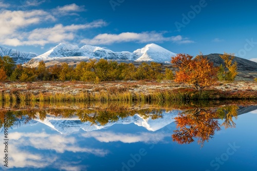 Reflection of the autumn landscape in Rondane National Park, snow-capped mountains, Doraldalen, Norway, Europe