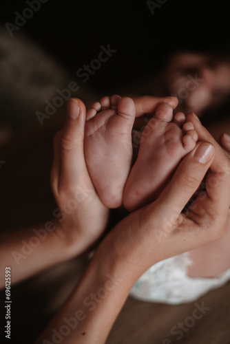 mother's hands holding baby's legs