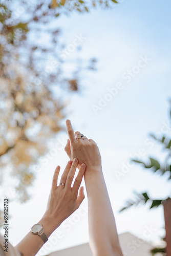 women's hands reach for the sky