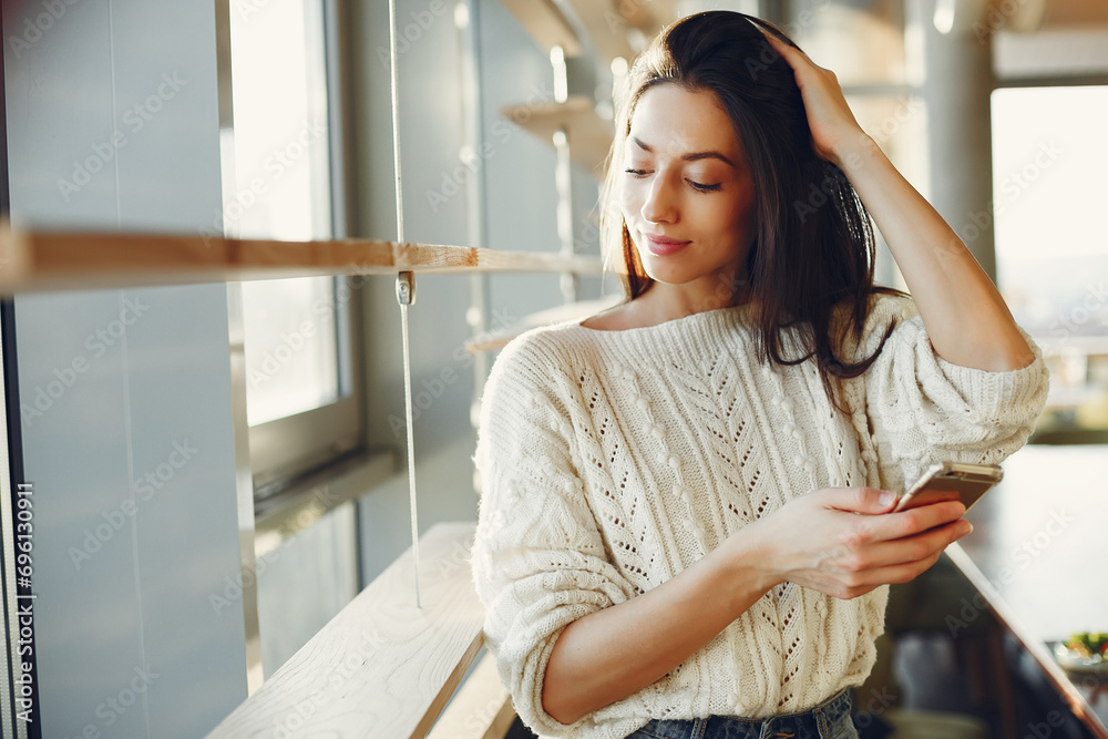 Businesswoman standing near window with phone Businesswoman standing near window with phone