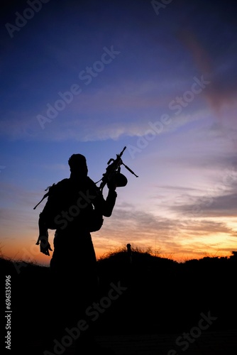 silhouette of a soldier with a rifle in sunset