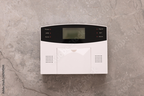 Home security alarm system on grey wall