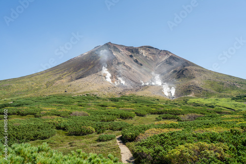 mount asahidake with sulfur vents steam rising into the air photo