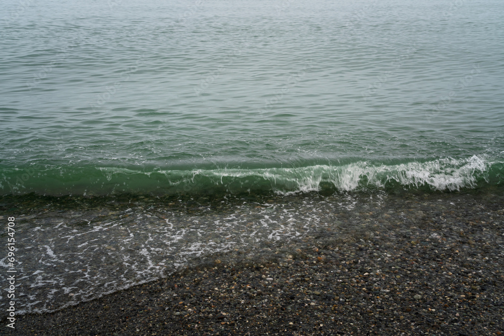An incoming wave on the Black Sea and a pebble beach on the Sochi coast on a summer day, Sochi, Krasnodar Territory, Russia An incoming wave on the Black Sea and a pebble beach on the Sochi coast on a summer day, Sochi, Krasnodar Territory, Russia