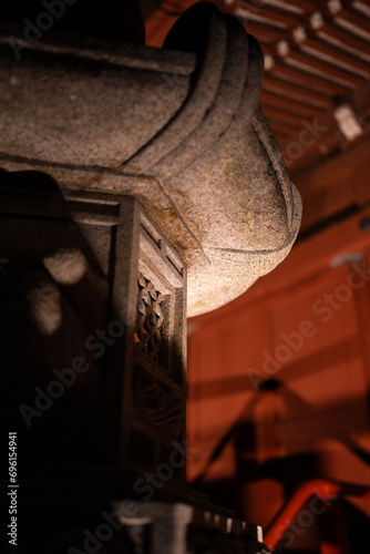 japanese stone lantern lit from the side at night at a temple in tokyo japan