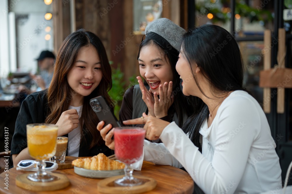 Group of attractive Asian female friends are enjoying talking in a cafe or restaurant, hanging out. Group of attractive Asian female friends are enjoying talking in a cafe or restaurant, hanging out.