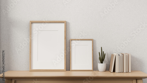 Minimal wooden picture frames on a wooden table against the white wall in a cosy Scandinavian room. photo