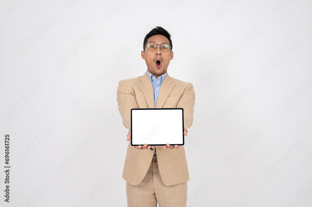 A excited Asian businessman is showing a digital tablet, standing on an isolated white background. A excited Asian businessman is showing a digital tablet, standing on an isolated white background.