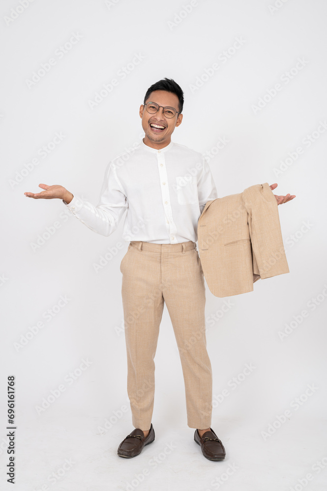 A smiling Asian businessman is opening his palms while standing on an isolated white background. A smiling Asian businessman is opening his palms while standing on an isolated white background.